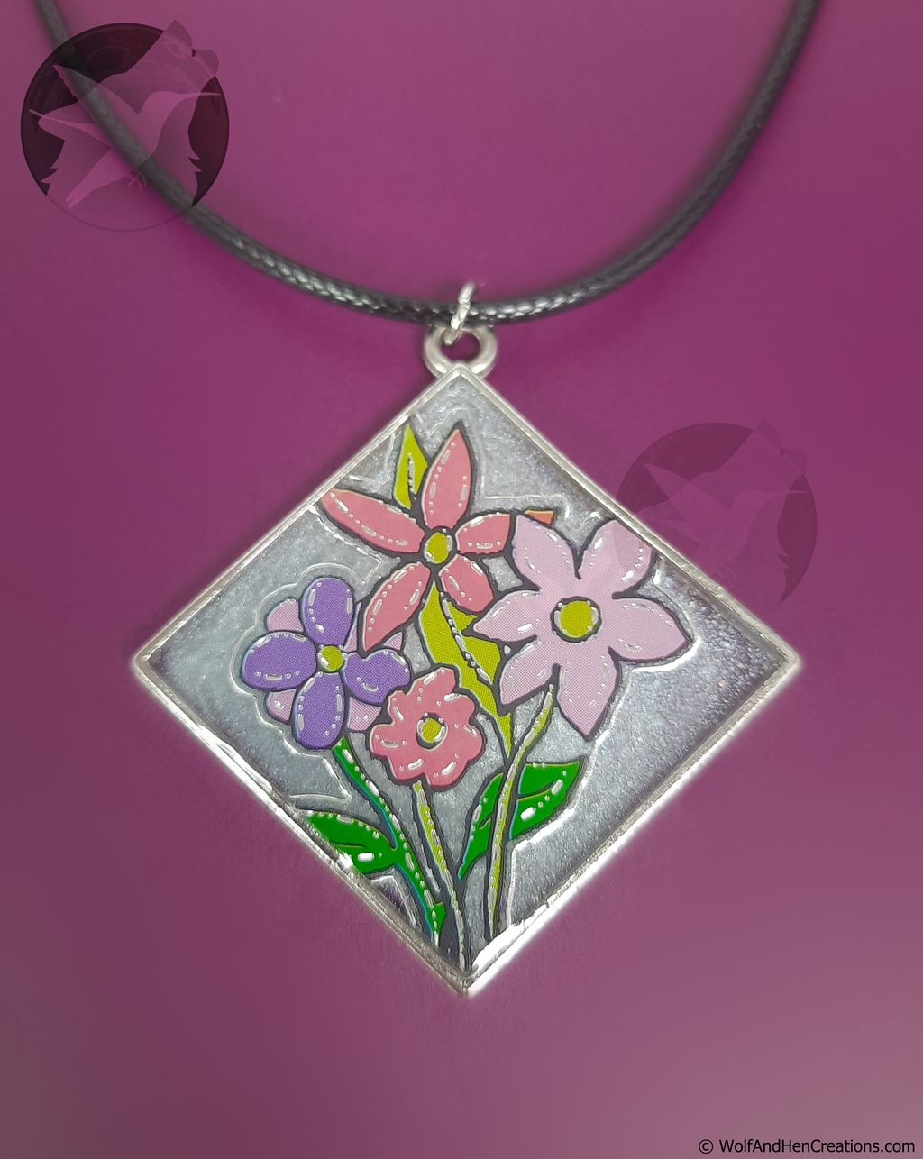 Diamond shaped pendant with floral design on a purple background