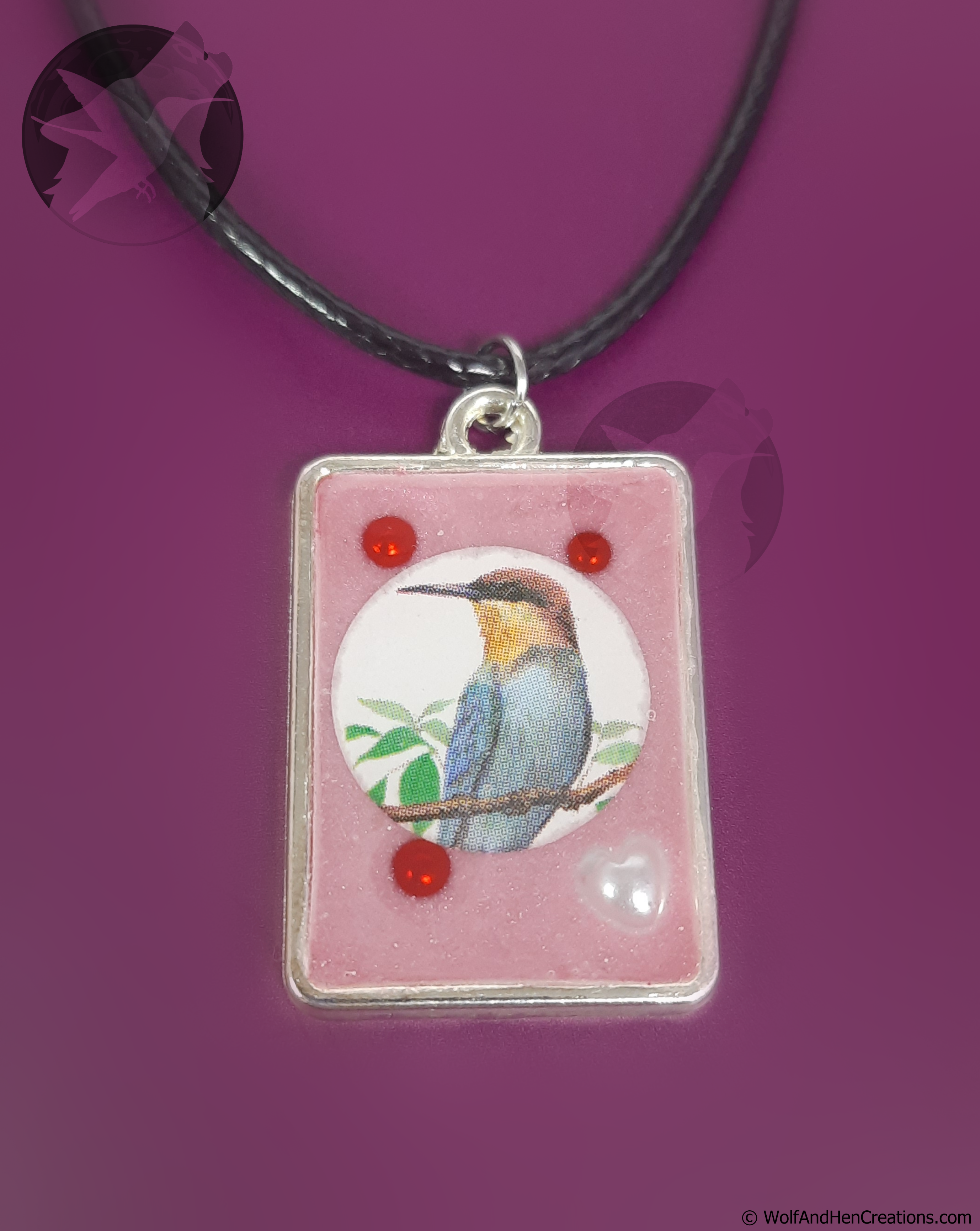 Bird pendant on a pink background with a purple border