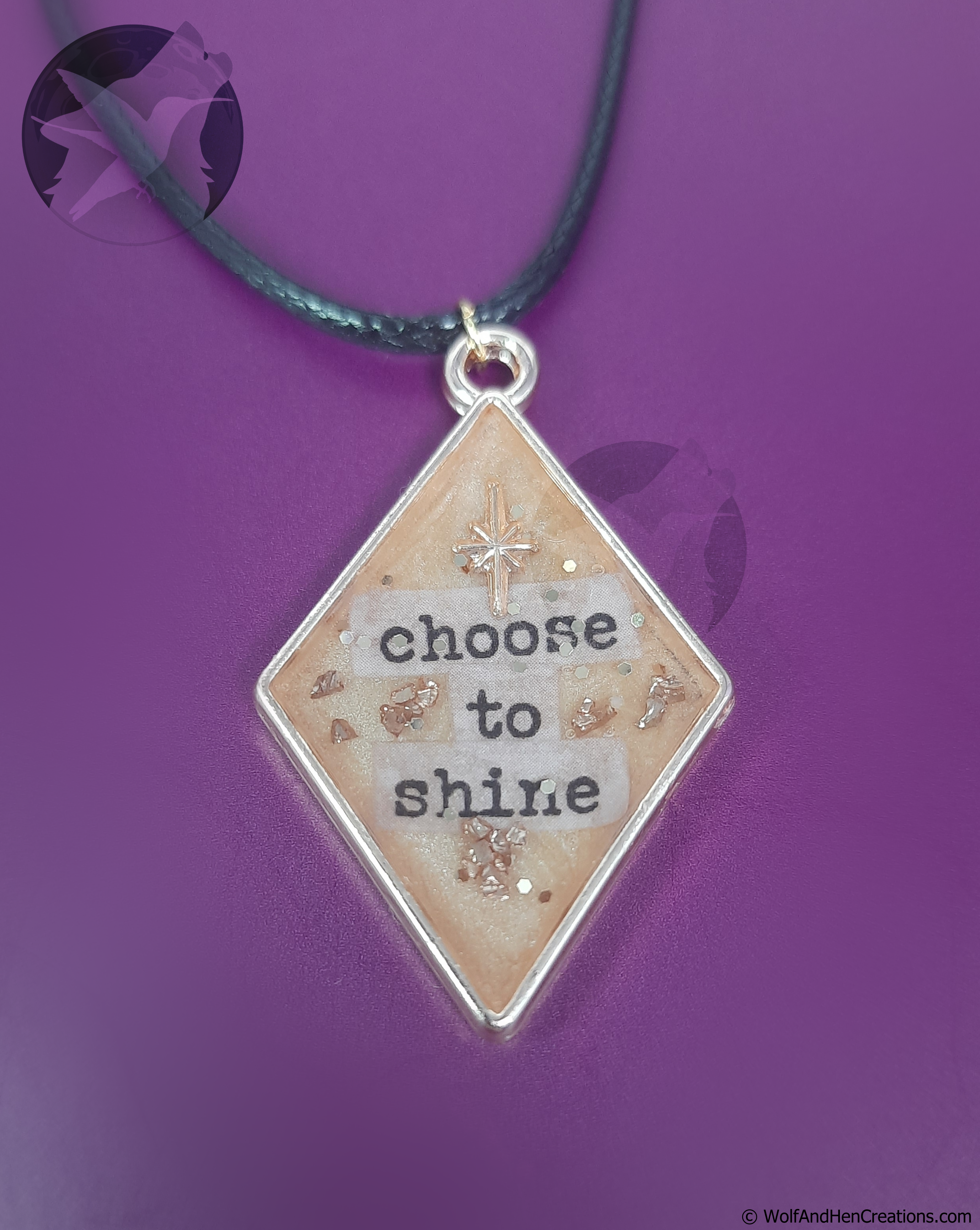 Necklace with a diamond-shaped pendant that says 'choose to shine' on a purple background.