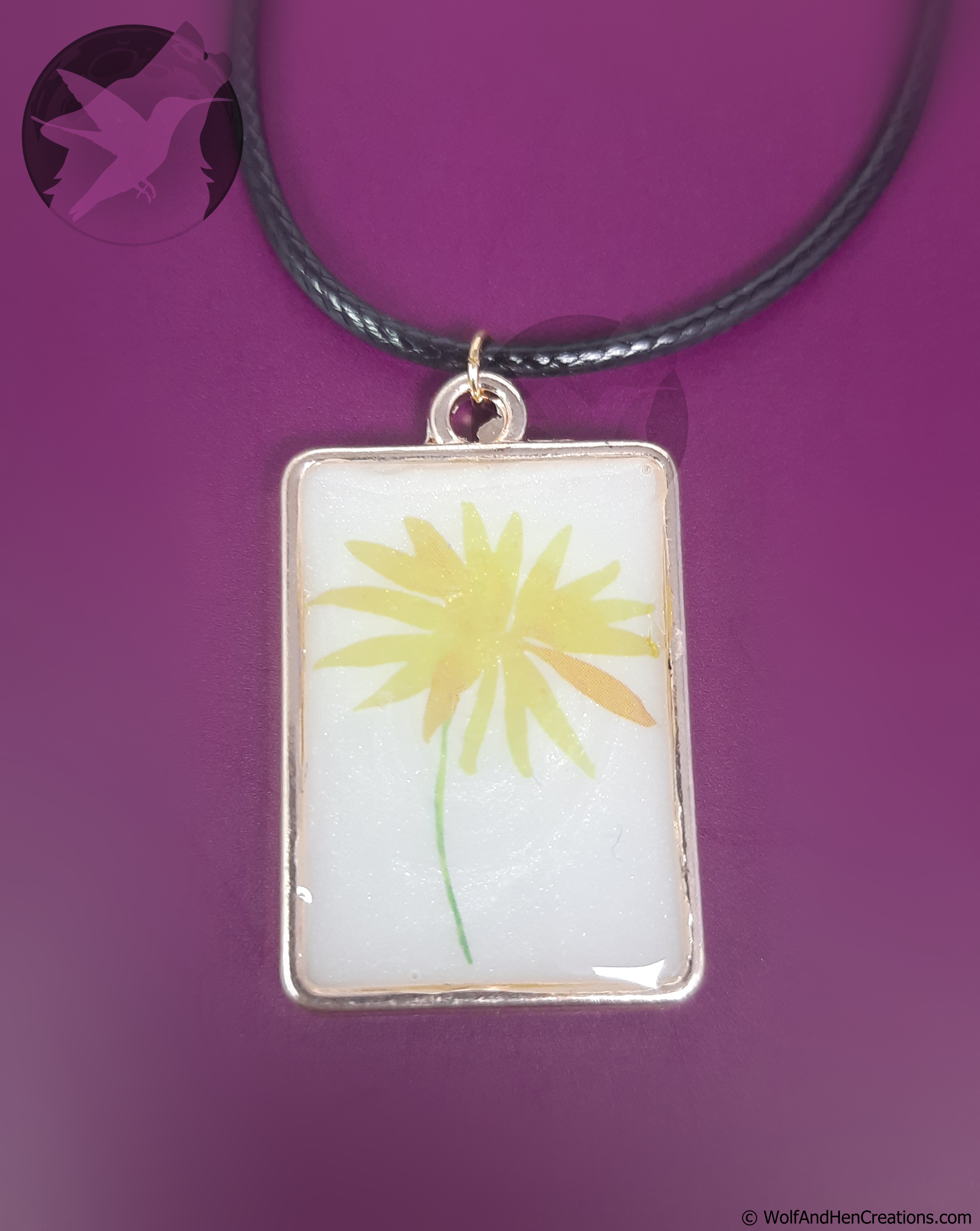 Necklace with a pendant featuring a yellow flower design on a purple background