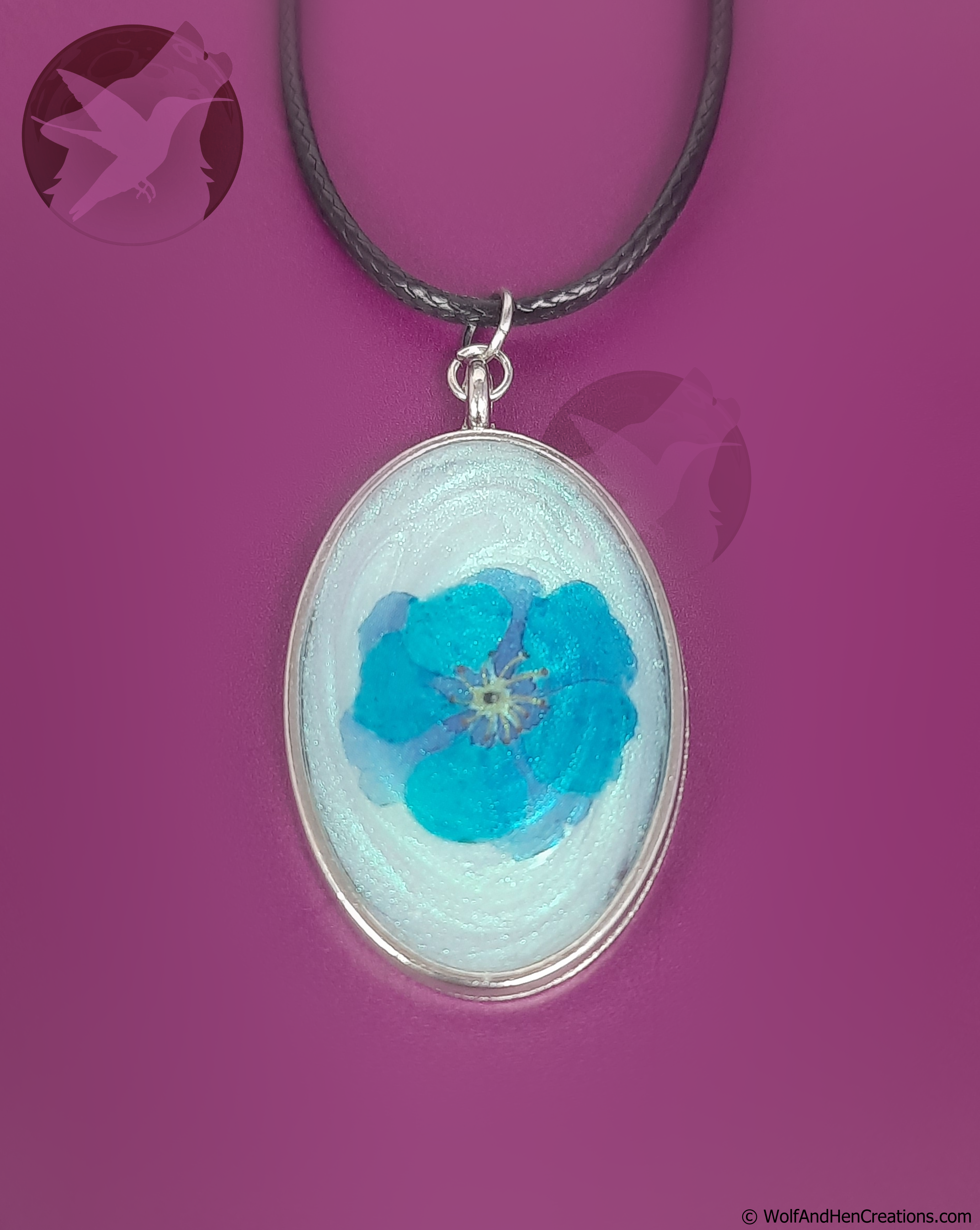 Necklace with an oval pendant featuring a blue flower on a purple background