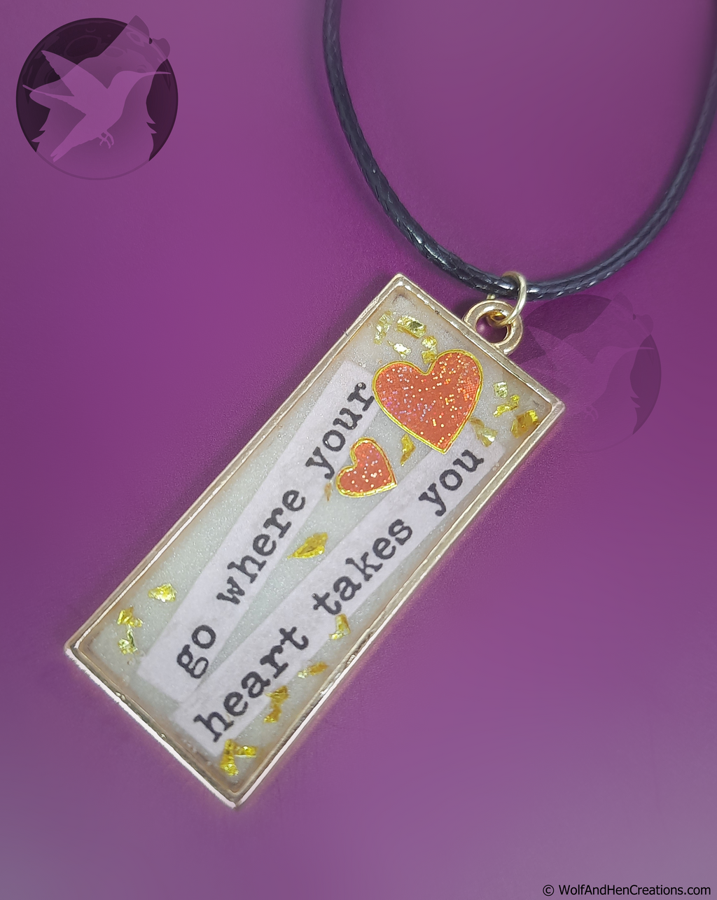 Necklace with a pendant featuring a heart and text on a purple background