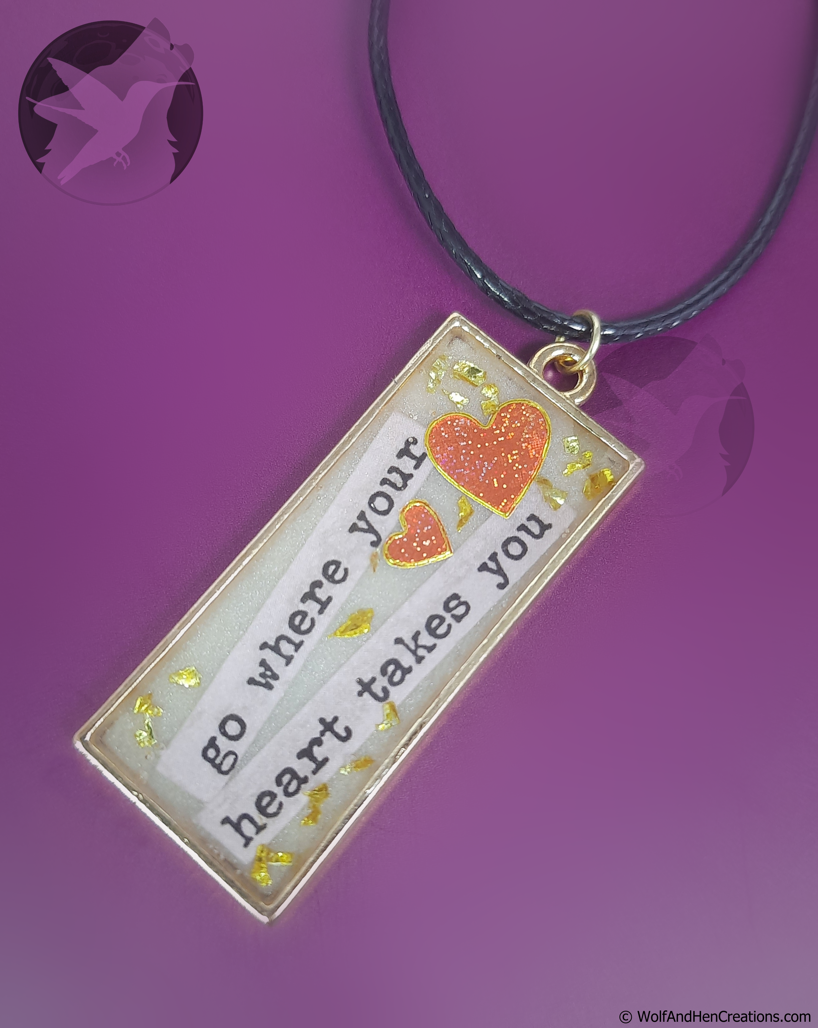 Necklace with a pendant featuring a heart and text on a purple background