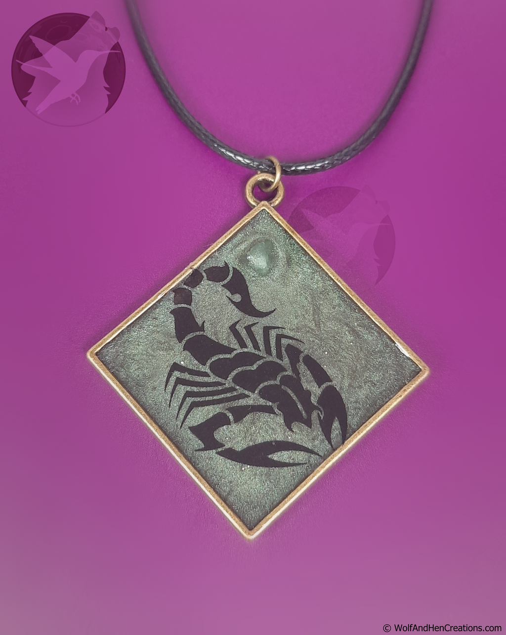 Scorpion pendant on a necklace against a purple background