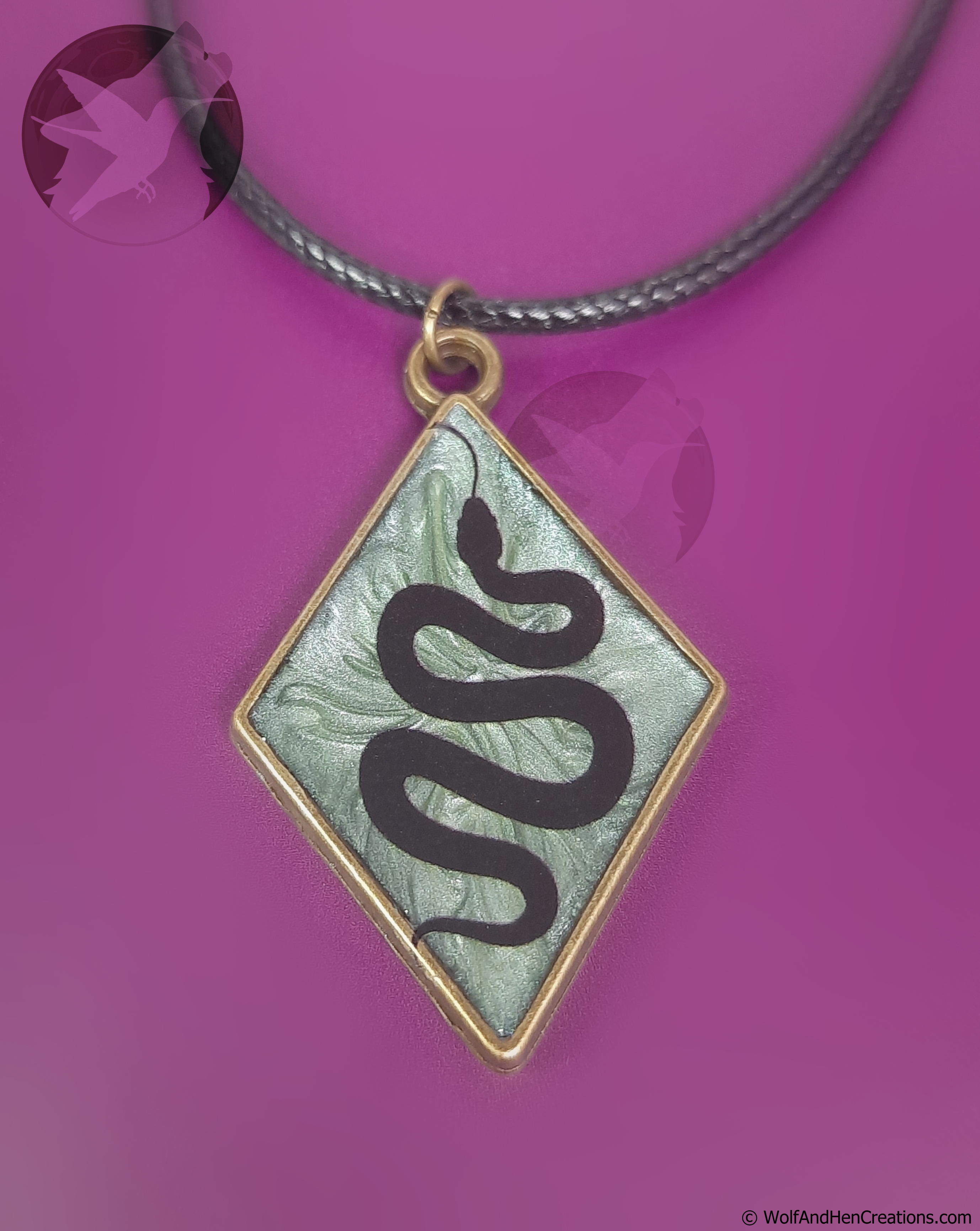 Necklace with a diamond-shaped pendant featuring a snake design on a purple background.