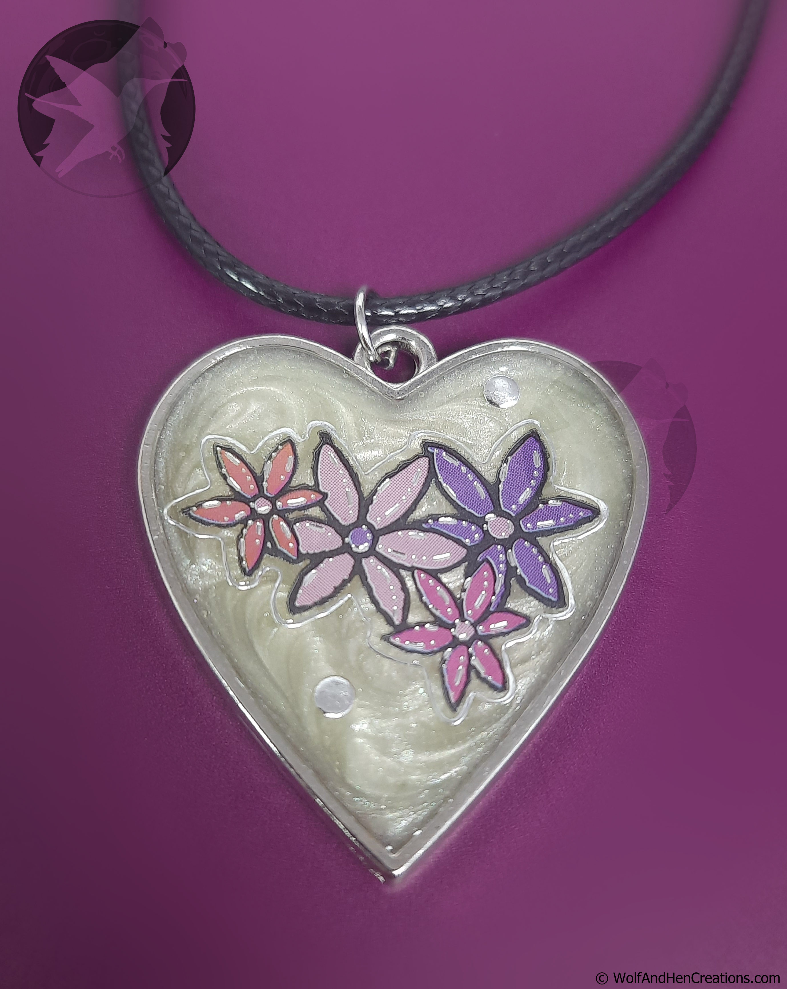 Heart-shaped pendant with floral design on a purple background