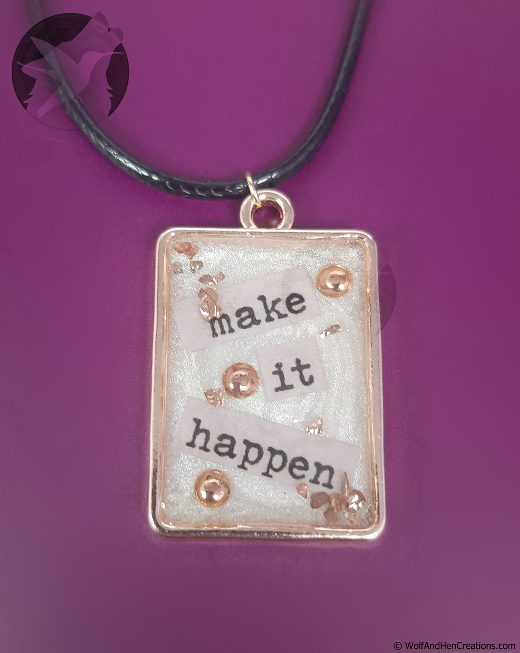 Necklace with a pendant that says 'make it happen' on a purple background