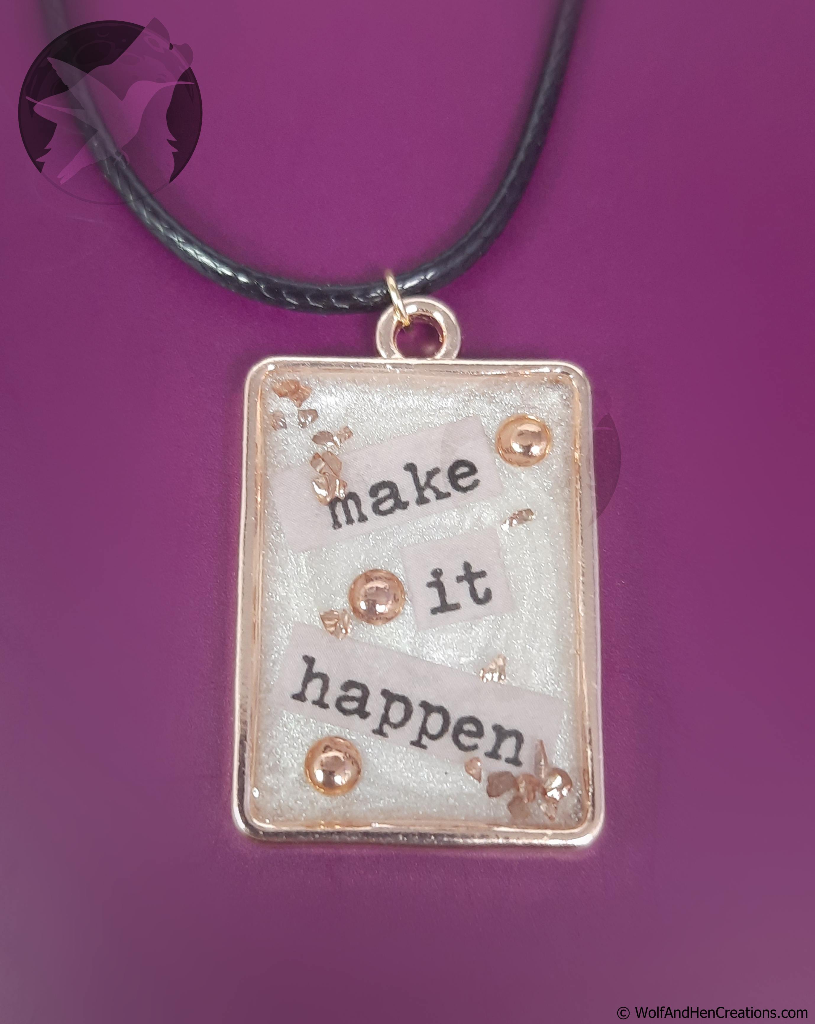 Necklace with a pendant that says 'make it happen' on a purple background