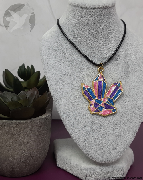 Necklace with a colorful crystal pendant on a mannequin bust, next to a potted plant.