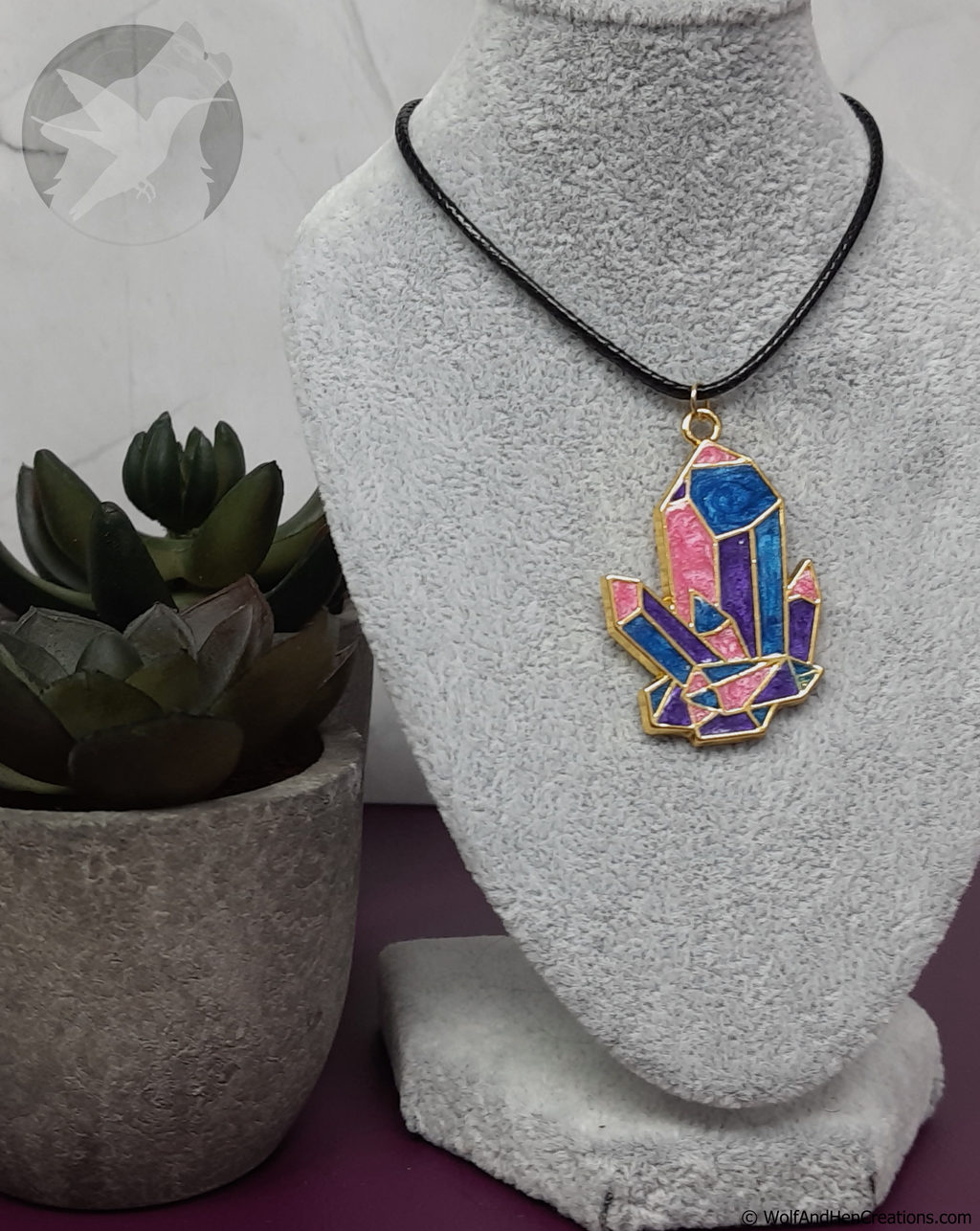 Necklace with a colorful pendant on a mannequin bust, next to a potted plant.