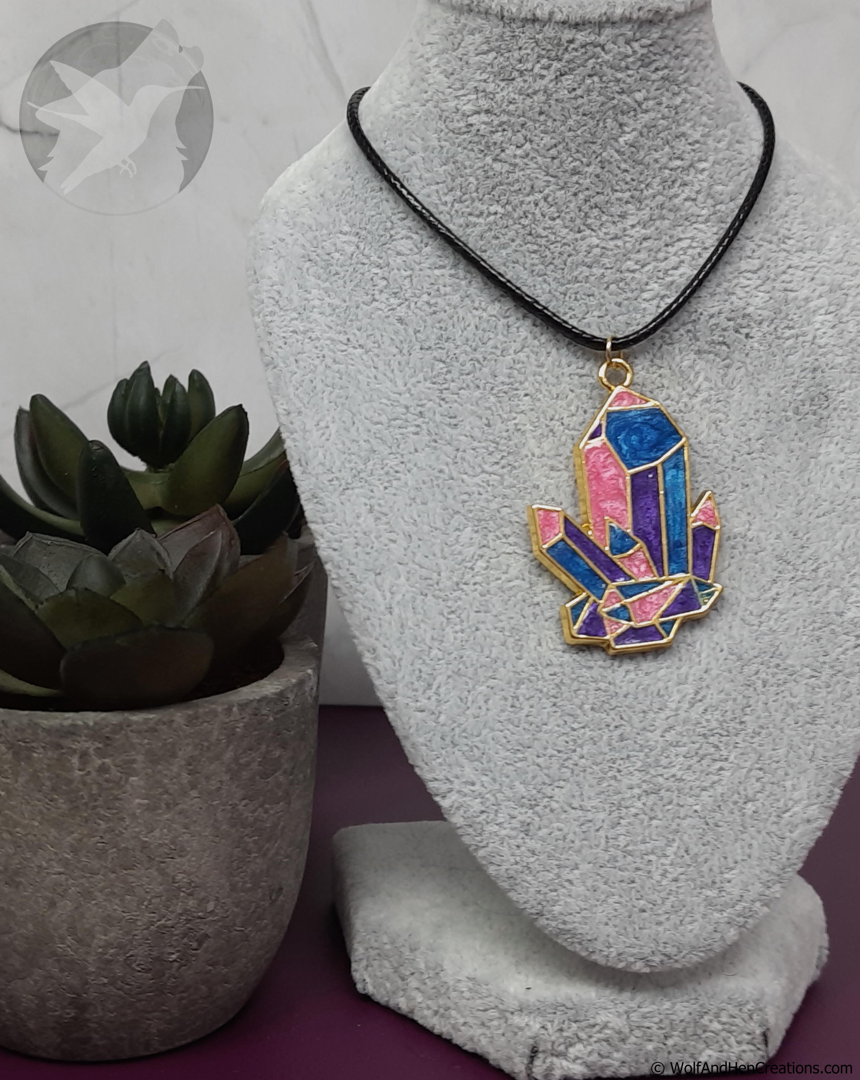 Necklace with a colorful pendant on a mannequin bust, next to a potted plant.